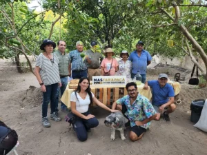 Productores locales junto al equipo técnico en terreno sosteniendo el letrero de MAS Tarapacá Pymes Sostenibles.