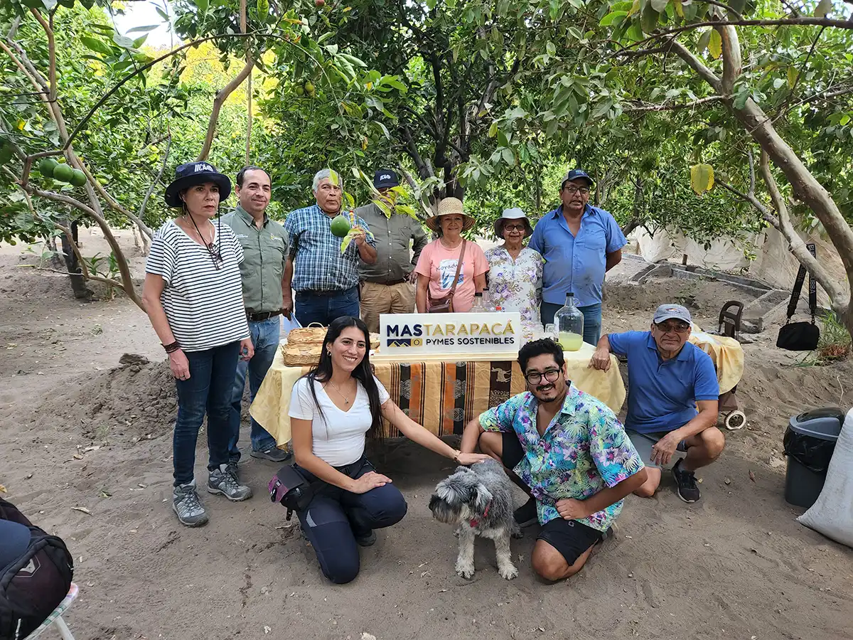 Productores locales junto al equipo técnico en terreno sosteniendo el letrero de MAS Tarapacá Pymes Sostenibles.